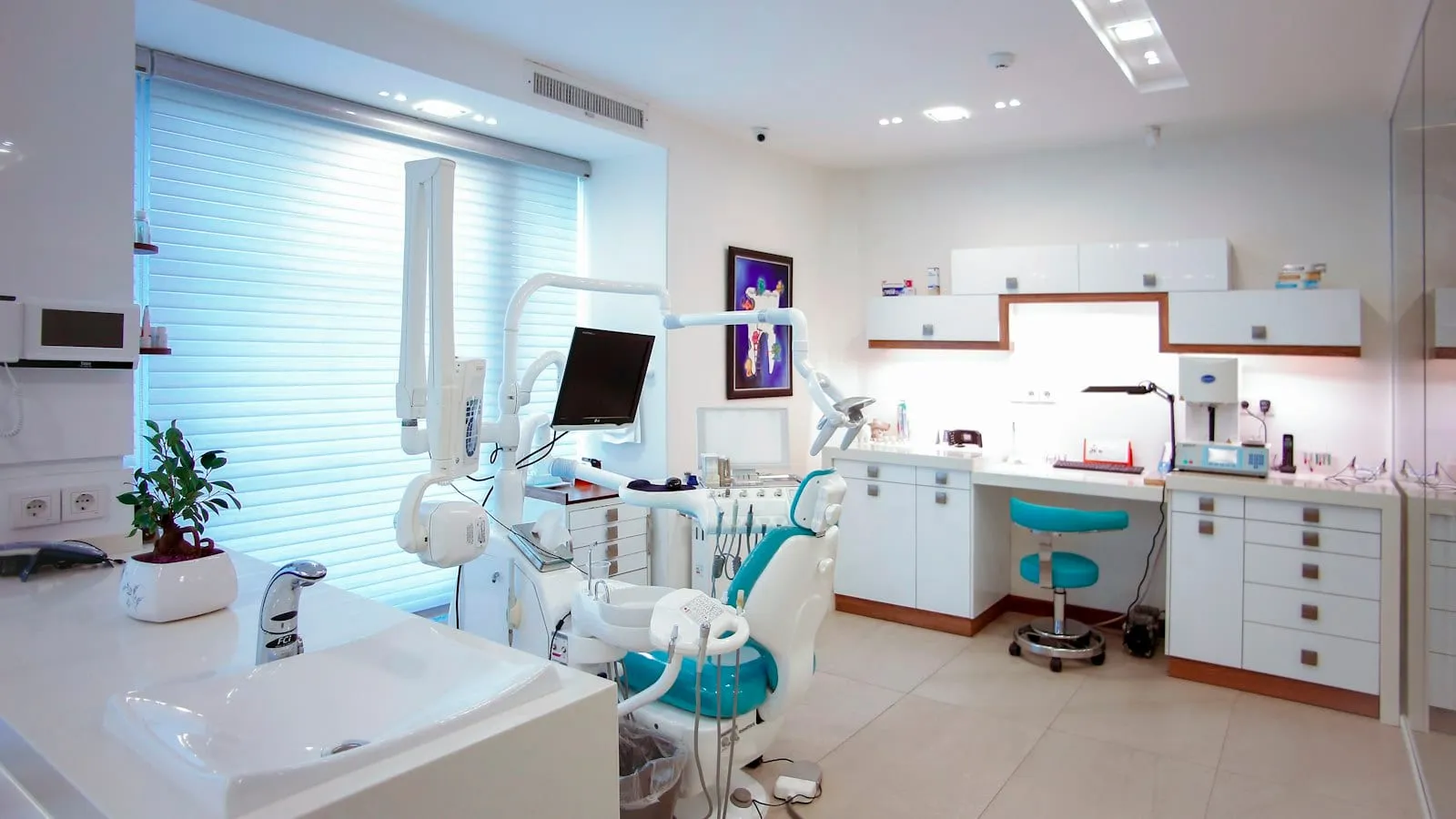 An empty, modern dental treatment room with a patient chair and equipment (stock photo)